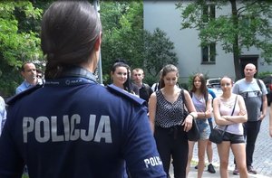 Uczestnicy zajęć oraz policjantka przed wejściem na teren Oddziału Prewencji Policji w Katowicach