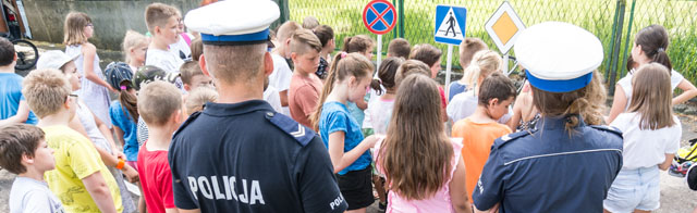 zdjęcie przedstawia policjantów i dzieci poznające znaki drogowe