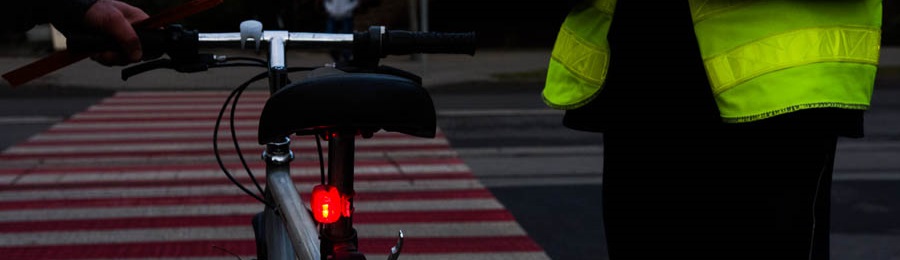 przejście dla pieszych - rower z włączonym tylnym światłem i policjant z boku
