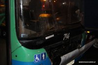 Zdjęcie przedniej szyby autobusu z wypaloną przez racę dziurą
