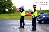 zdjęcie przedstawia dwóch umundurowanych policjantów drogówki podczas kontroli prędkości
