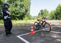 zdjęcie przedstawia - policjantkę i rowerzystkę rozpoczynającą egzamin na torze przeszkód