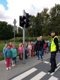 policjant i przedszkolaki przy przejściu dla pieszych