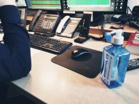 zdjęcie biurko dyżurnego w tle monitory i telefony a z prawej butelka bioseptolu
