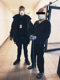 zdjęcie - policjant po cywilu i zatrzymany w kajdankach, obaj z maseczkami