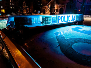 zdjęcie policyjnego radiowozu nocą ze świecącym napisem policja