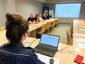 zdjęcie przedstawia salę narad komendy w czasie szkolenia, prowadząca szkolenie wyjaśnia na pokazanym slajdzie przepisy