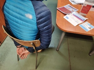zdjęcie przedstawiające siedzącego w komisariacie fałszywego wolontariusza