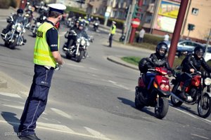 zdjęcie poglądowe - policjant z drogówki przy kolumnie przejeżdżających motocyklistów