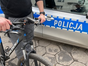 zdjęcie poglądowe rowerzysty stojącego przy policyjnym radiowozie